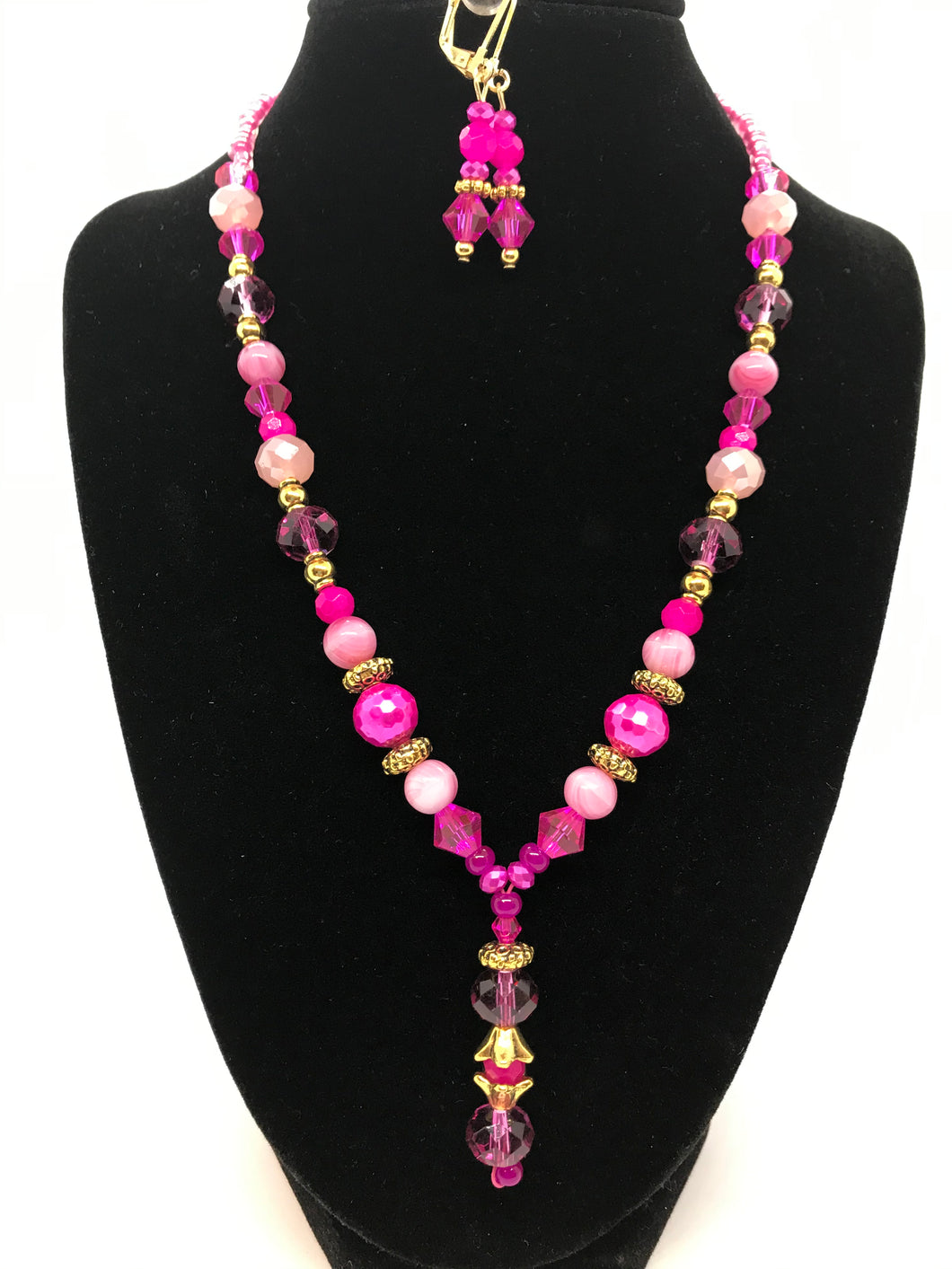 Hot pink necklace with dangling focal piece, matching earrings.