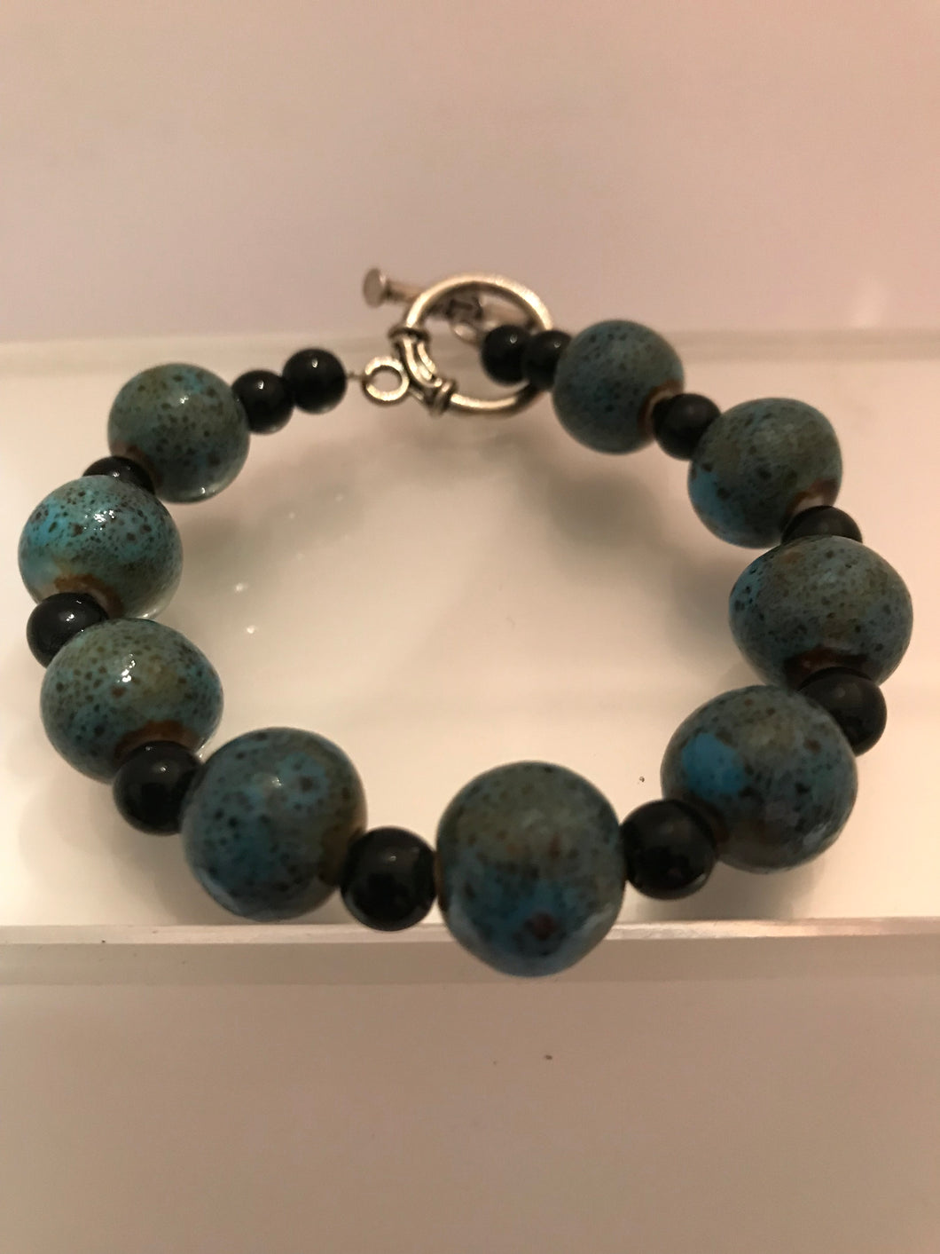 Dark green/blue stone beads with black accent spacers.
